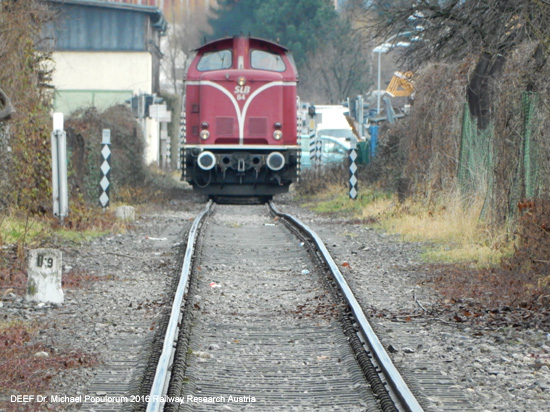 Die Stieglbahn heute: die rote SLB-Diesellok auf dem eingleisigen, teils überwachsenen Gleis mitten in der Stadt